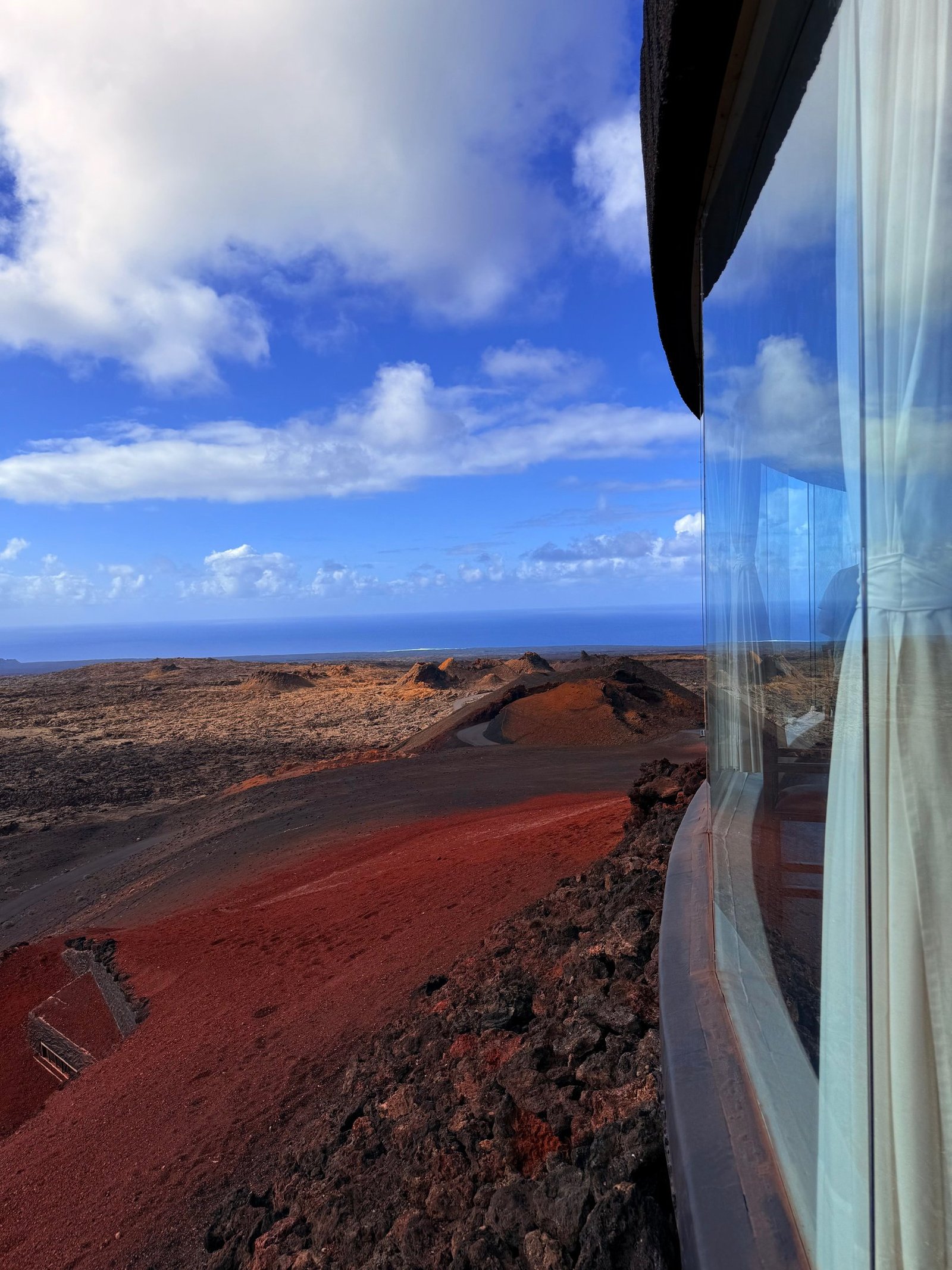 View across Lanzarote red volcanic landscape from a panoramic window