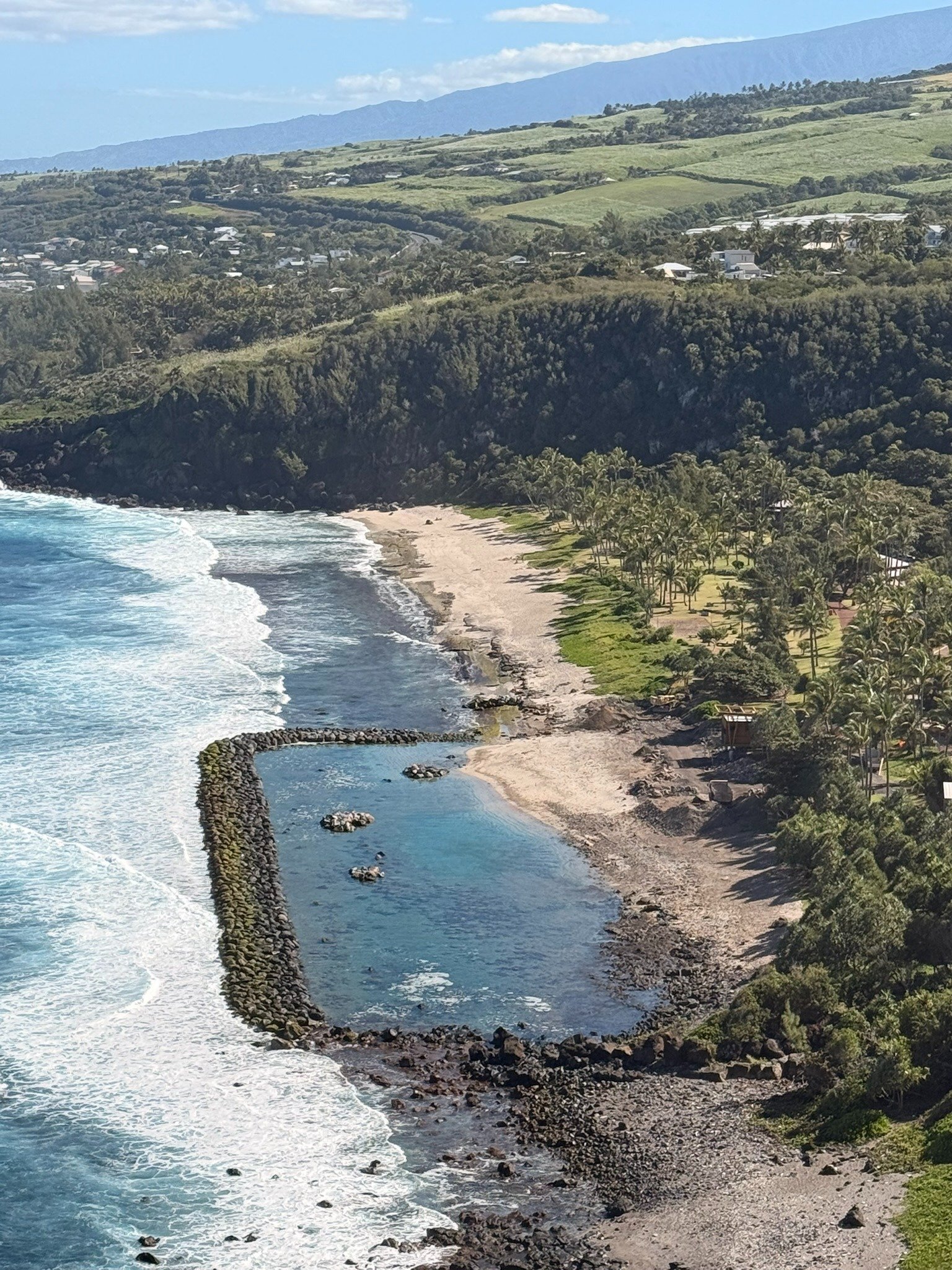 Bassin marin naturel protégé par une barrière rocheuse sur la côte de La Réunion, vu d’en haut