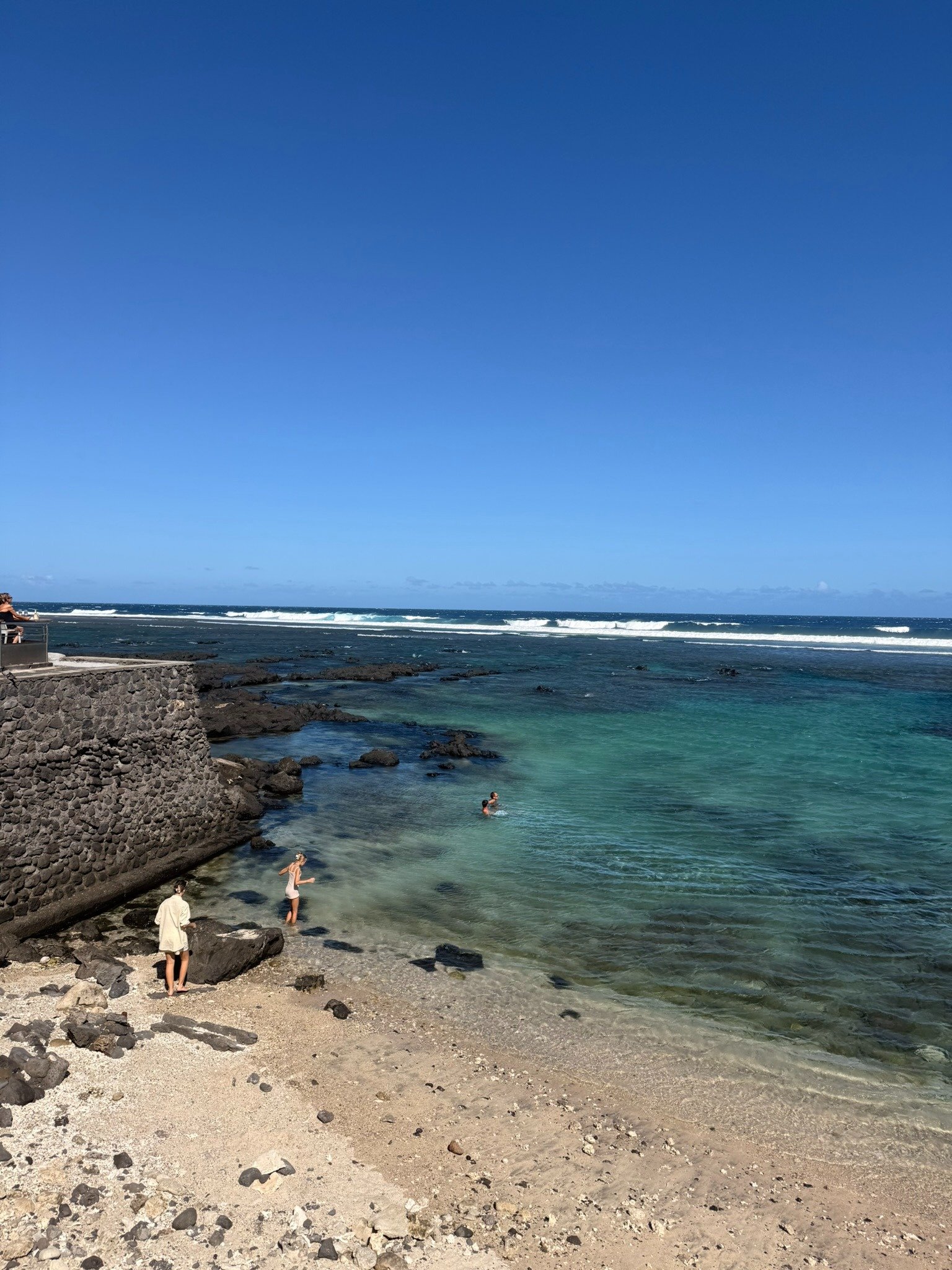 Eau peu profonde et protégée du lagon de Saint-Pierre, avec les vagues se brisant sur le récif au large